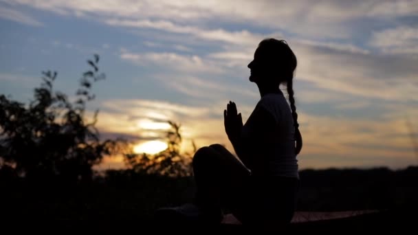 Žena cvičí jógu večer při západu slunce. — Stock video