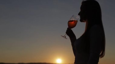 Gün batımında kokteyl içen kız.