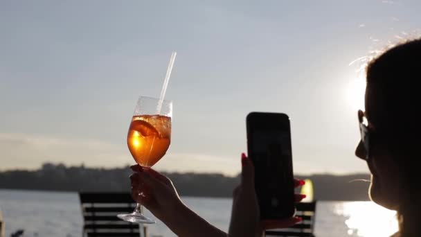 Eine Frau Trinkt Einen Orangefarbenen Cocktail Und Fotografiert Ihn Mit — Stockvideo