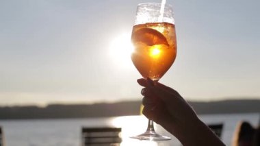 Gün batımında elinde portakal kokteyli