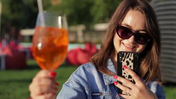 Bir Kadın Portakal Kokteyli Içer Akıllı Telefonuyla Fotoğrafını Çeker — Stok video