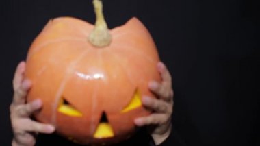 Tüm Cadılar Bayramı çift. Adam kafasına balkabağı koyuyor..