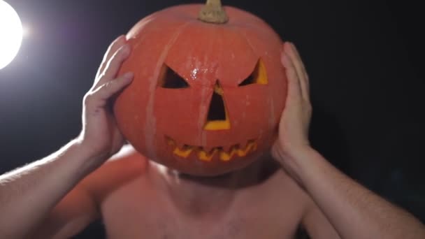 Ovanligt par på halloweenfesten. Man med snidade pumpa på huvudet och rolig kvinna nära pumpa pojke — Stockvideo