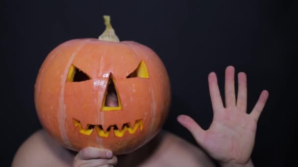 Ovanligt par på halloweenfesten. Man med snidade pumpa på huvudet och rolig kvinna nära pumpa pojke — Stockvideo