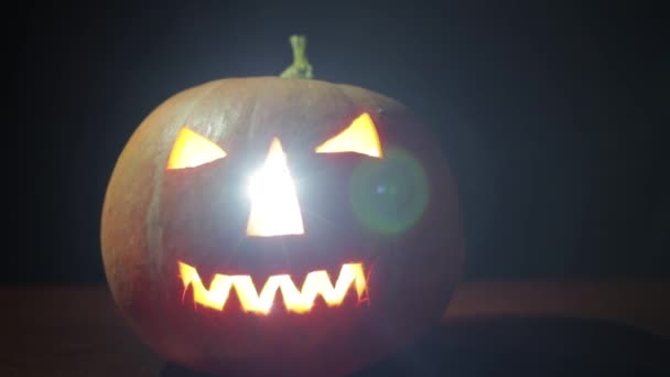 Страшные тыквы на Хэллоуин изолированы на черном фоне. Страшные светящиеся лица — стоковое видео