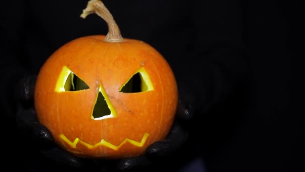 Pumpan lyser i händerna på en man. Halloween kväll. — Stockvideo