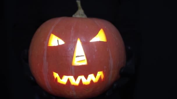 Halloween pumpa med eld och skugga av en svart katt. Halloween eller är ett firande observeras. Pumpa glöder på Halloween kväll. Alla helgon Även — Stockvideo