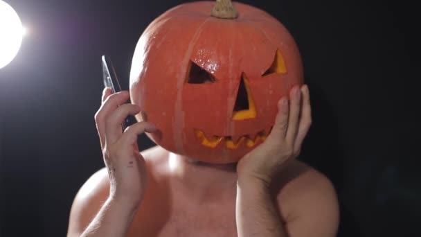 A férfiak egy tököt takarítanak, felkészítik Halloween ünnepére. Közelkép egy narancssárga tökről. — Stock videók