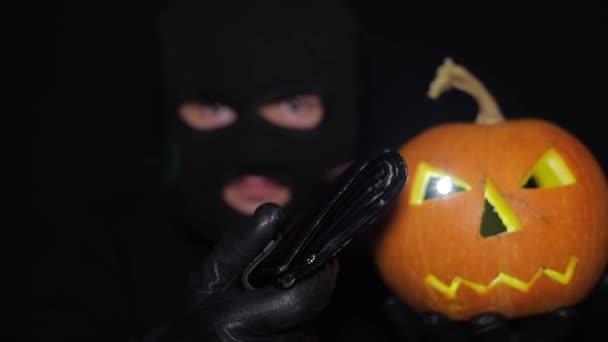 Um ladrão com uma máscara e com uma faca na mão na noite de Halloween. — Vídeo de Stock