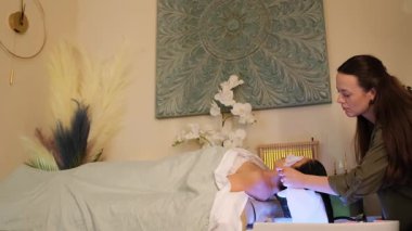 Spa ortamında kadın yüz bakımı üzerine çalışan profesyonel terapist..