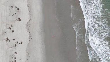 Sahilin manzarası, sahilde dinlenen bir kadın. Drone görünümü.