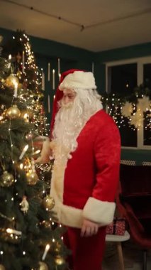 Noel Baba gibi giyinmiş bir adamın Noel 'i kutladığı, neşeli ruhu yakaladığı bir video. Dikey video.