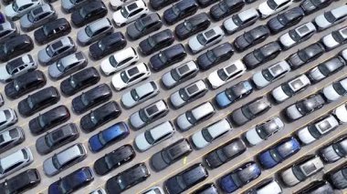 Kalabalık bir hava görüntüsü, kalabalık bir park yerinde park halindeki bir sürü arabayı gösteriyor.