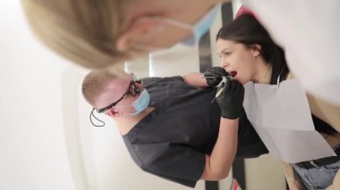 Diş hekimi kapsamlı bir sözlü muayene gerçekleştirirken, hasta çeşitli diş bakımı görmektedir.