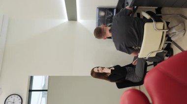 Bir sağlık uzmanı, modern bir muayenehanede bir hastayla tedavi seçeneklerini tartışıyor..