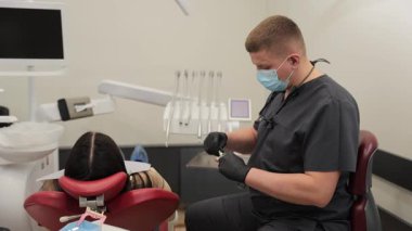 Modern bir klinikte gelişmiş yöntemler ve araçlar kullanılarak yapılan diş tedavisi.