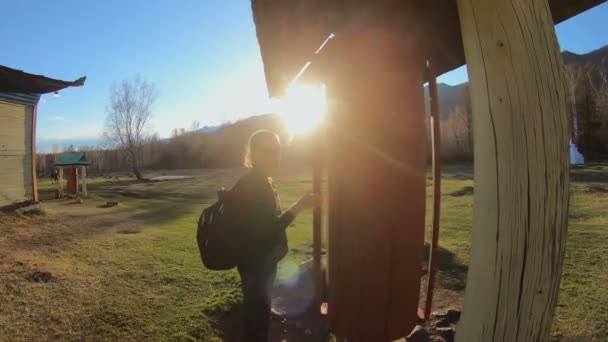 Tourist girl spins a prayer wheel next to a Buddhist temple at sunny day — Stock Video