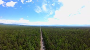 Yolun ormana havadan görünümü. Arabalar hareket. Bird's-Eye view. Güzel manzara. Uçan, hava kamera atış robot. Sibirya. 4k