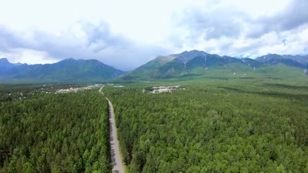 Vue aérienne spectaculaire sur les montagnes, le paysage forestier vert, la route et la ville — Video