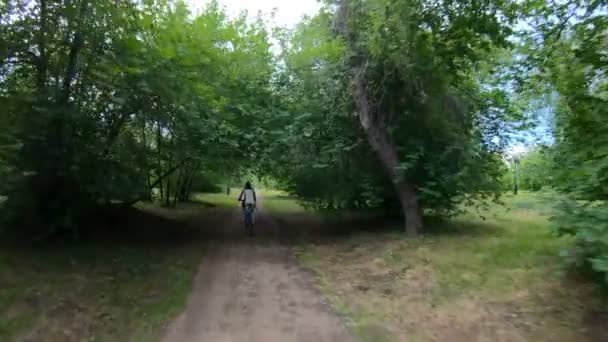 Parkta Bisiklete binme. Kız bir orman iz üzerinde bisiklete binmek. Ağır çekim — Stok video