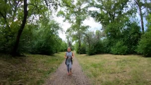 Correr en el parque. Chica corriendo por el sendero del bosque. Movimiento lento — Vídeos de Stock