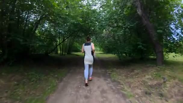 Correr en el parque. Chica corriendo por el sendero del bosque. Movimiento lento — Vídeo de stock