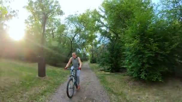 Faire du vélo dans le parc. Fille en vélo sur un sentier forestier. Mouvement lent — Video