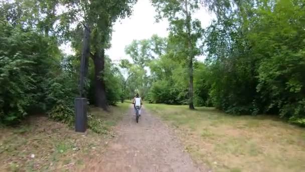 Parkta Bisiklete binme. Kız bir orman iz üzerinde bisiklete binmek. Ağır çekim — Stok video