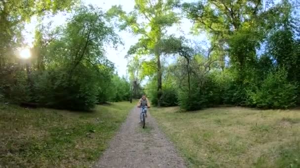 Ciclismo en el parque. Chica montando en bicicleta en un sendero forestal. Movimiento lento — Vídeos de Stock