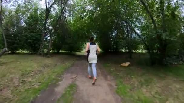 Kocogás a parkban. Lány fut végig az erdei ösvényen — Stock videók