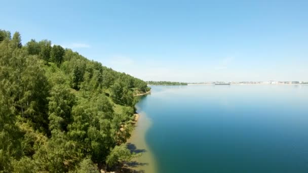 De drone vliegt boven de groene kust naar de stad — Stockvideo