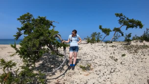 Meisje raakt een boomtak op het strand — Stockvideo