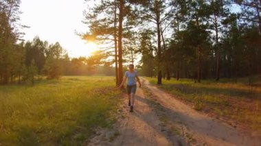 Gün batımı bir ülke yolda yürüyüş şort ve mavi gözlük kız
