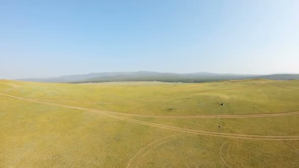 Drone vuela de nuevo sobre el prado amarillo y la costa — Vídeos de Stock
