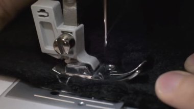 Dikiş makinesinde siyah kumaş dikiş sürecinin yavaş çekim çekim