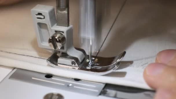 El primer plano de la aguja de la máquina de coser se mueve rápidamente hacia arriba y hacia abajo. Tejido blanco — Vídeos de Stock