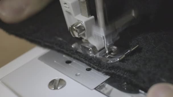 Le processus de couture du tissu de laine noire sur la machine à coudre 