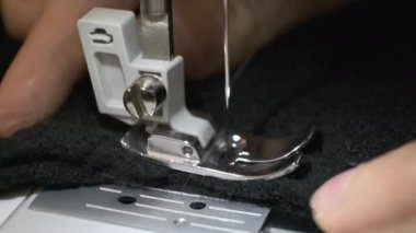 Dikiş makinesinde siyah yünlü kumaş dikme işlemi