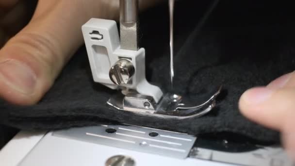 Close-up van naaimachine naald beweegt snel op en neer. Zwarte stof — Stockvideo