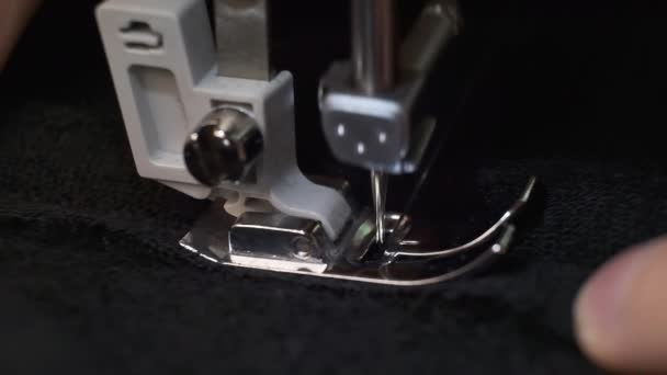 Slow motion skott av processen att sy svart tyg på symaskinen — Stockvideo