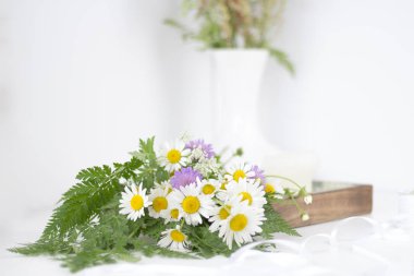 Güzel papatyalar ve beyaz bir masaya diğer çiçek.