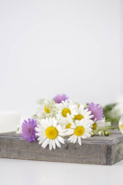 Papatya ve beyaz bir masaya diğer çiçek.