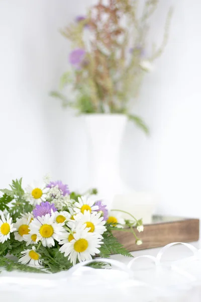 Güzel papatyalar ve beyaz bir masaya diğer çiçek.