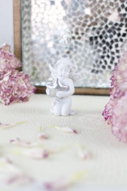 Beyaz melek üstünde okul sırası. Beyaz masa üzerinde güzel pembe çiçekler.