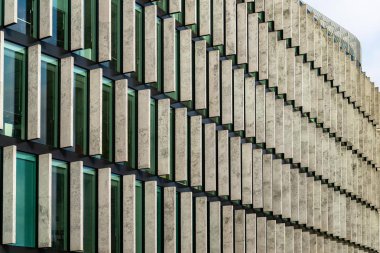 Cam gökdelenler düzensiz şeklin. Alt görünümü. Soyut mimari detay kurumsal binanın arka plan olarak uygun. Beton ile pencereler arasında ekler çıkıntılı.