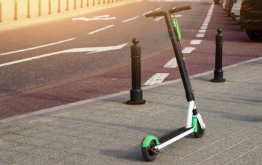 Elektrikli scooter yolda park etmiş. Modern ekolojik şehir mobiletleri kaldırım kenarında kiralık. Alternatif taşıma. E-scooterlar bir uygulama ile kiralanabilir