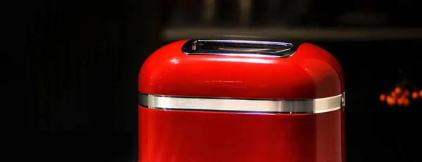 Red stylish retro toaster on dark background. For the purposes of advertising and blogs