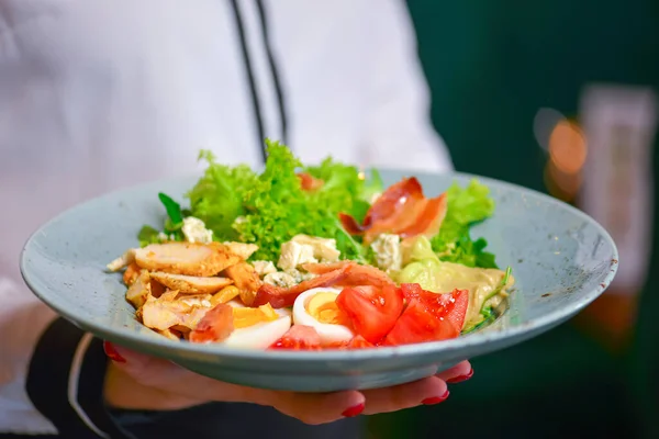 Salada César Orgânica Verde Saudável com Queijo e Croutons. Garçom de uniforme branco, camisa, servindo salada de césar . — Fotografia de Stock