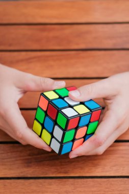 Rubiks küpünü tutan ve masada oynayan sevimli çocuk portresi. Rubiks küpü çocukların elinde. Pankart.