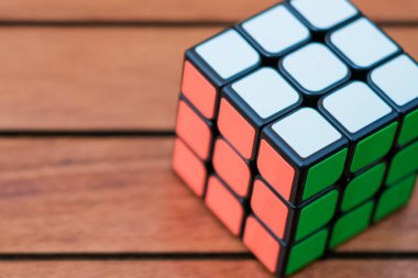 Ahşap arka planda Rubiks küpü. Kapatın. Uzay afişini kopyala. Ahşap arka planda renkli bir oyuncak.